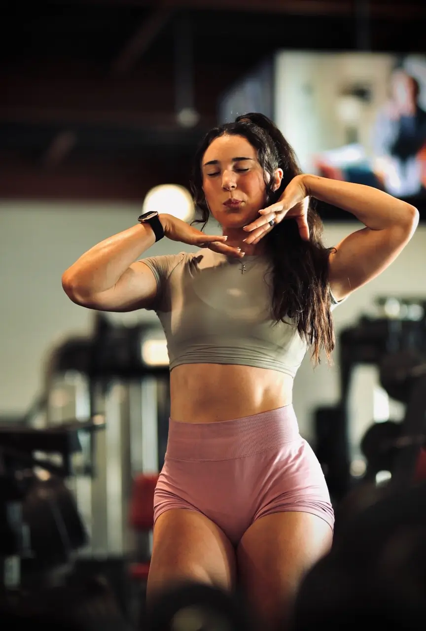Coach Emily posing friendly gesture inside a fitness gym